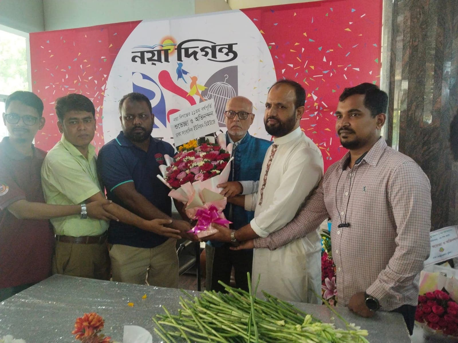 Guests presenting flowers at a newspaper anniversary event